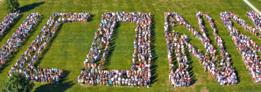 an aerial view of UConn students standing on the Great Lawn in a formation that spells UConn